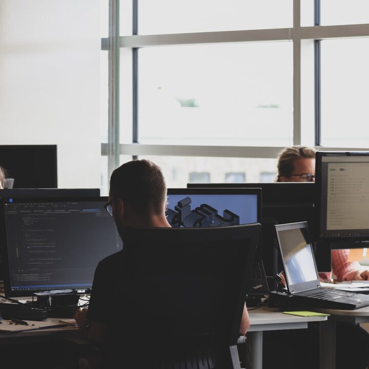 people sitting on chair in front of computer monitor